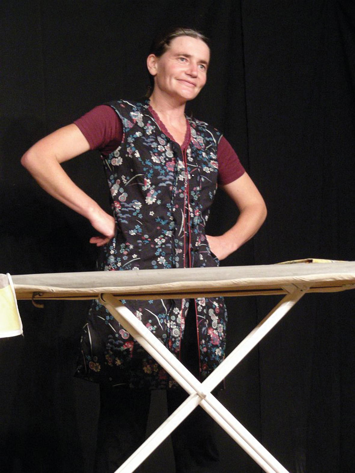 Véronique Blot sur scène incarnant Bernadette la braconnière solognote, Elle est
	    derrière une planche à repasser et à les mains sur les hanches, Photo prise à la première
 	   représentation de Cœur de braco au musée La Maison du braconnage à Chaon, Loir-et-Cher